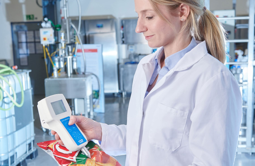 Frau in einem Labor mit Prüfgerät in der Hand